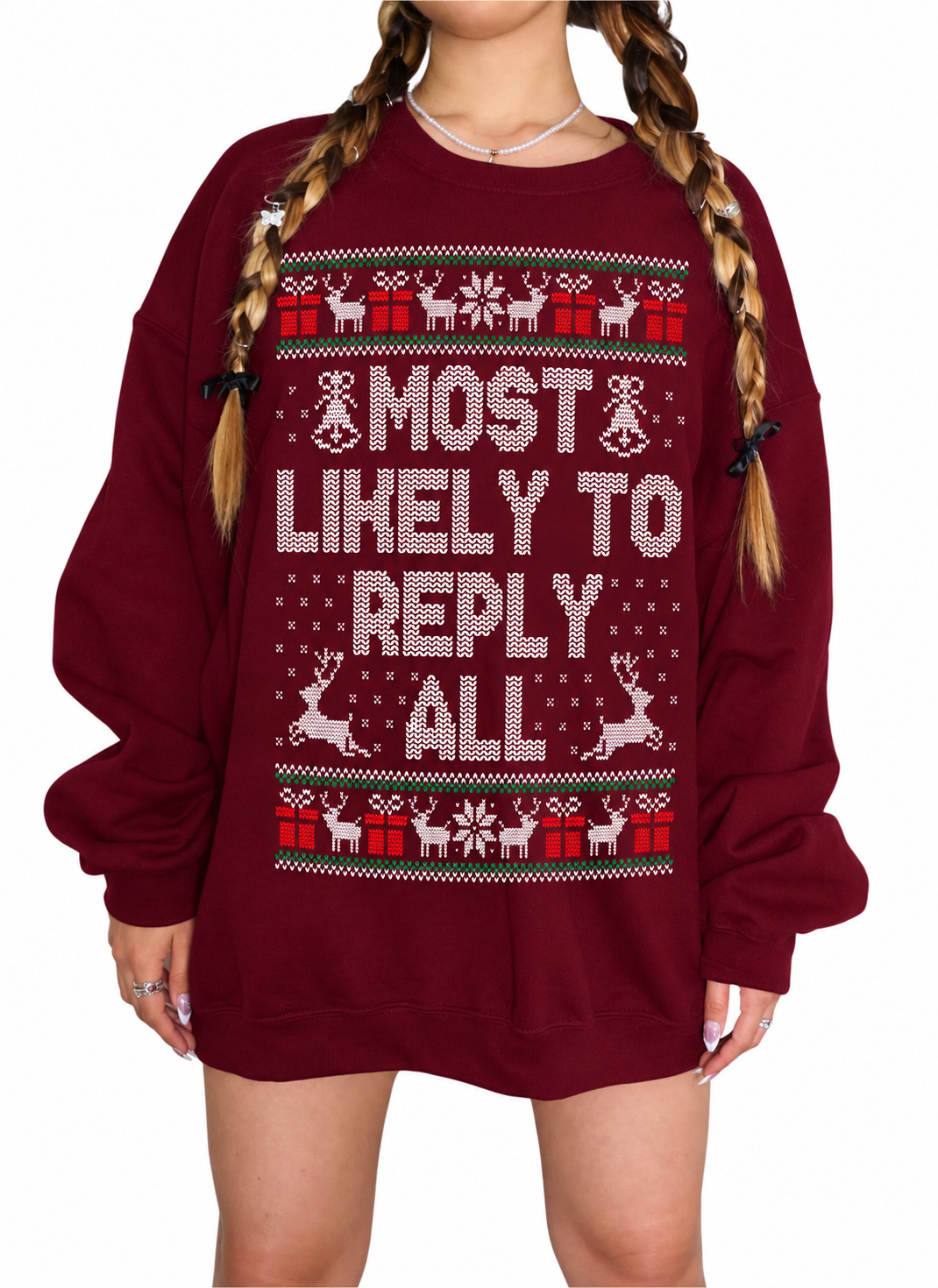 A woman wearing an oversized maroon crewneck sweatshirt with a festive Christmas pattern and the text 'MOST LIKELY TO REPLY ALL' in white and red.
