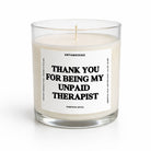 A glass jar candle with cream-colored wax and a white label featuring bold black text that reads 'THANK YOU FOR BEING MY UNPAID THERAPIST' by UNTAMEDGOGO, on a clean white background.