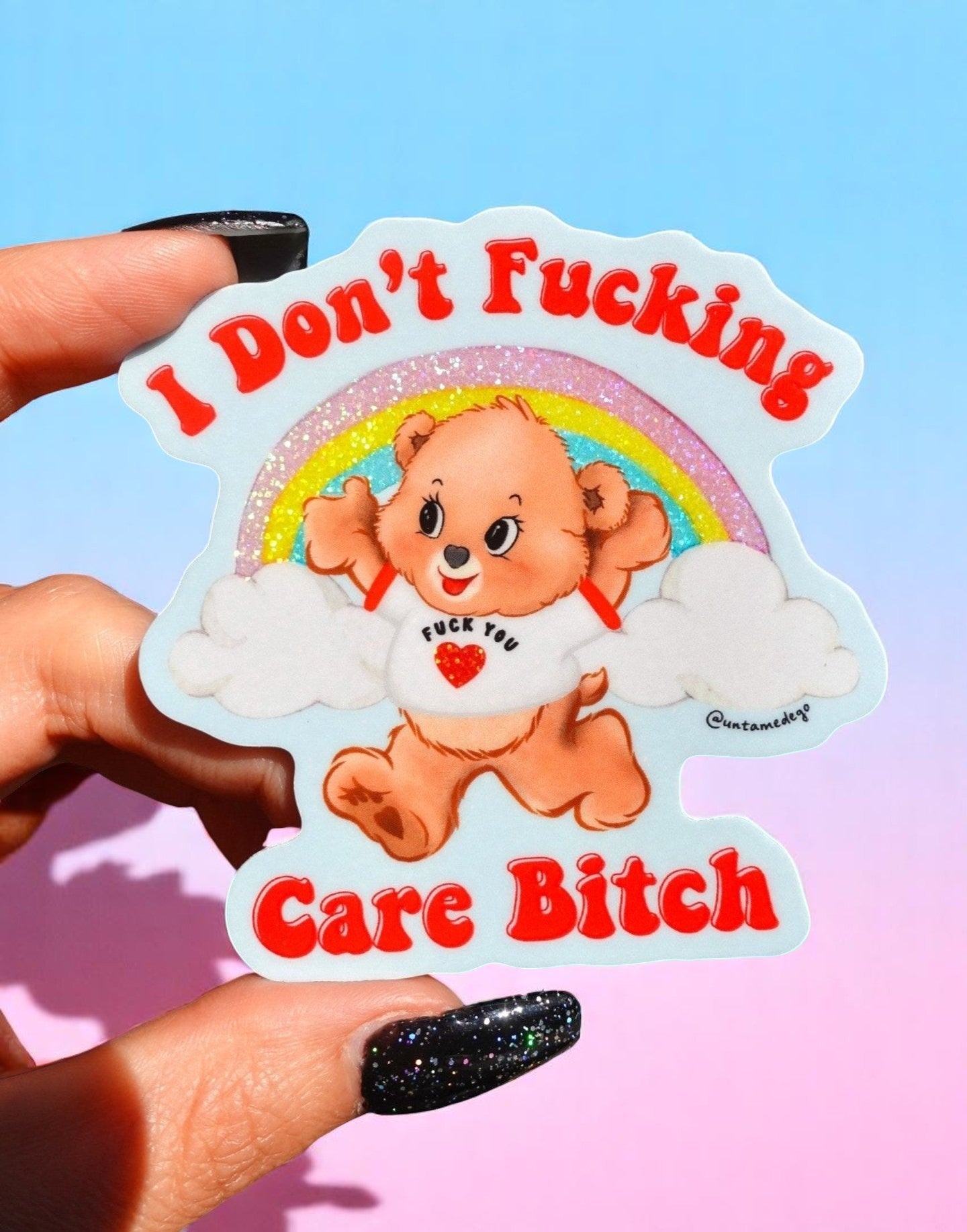 Sticker with a bear character and text held by a hand against a colorful background