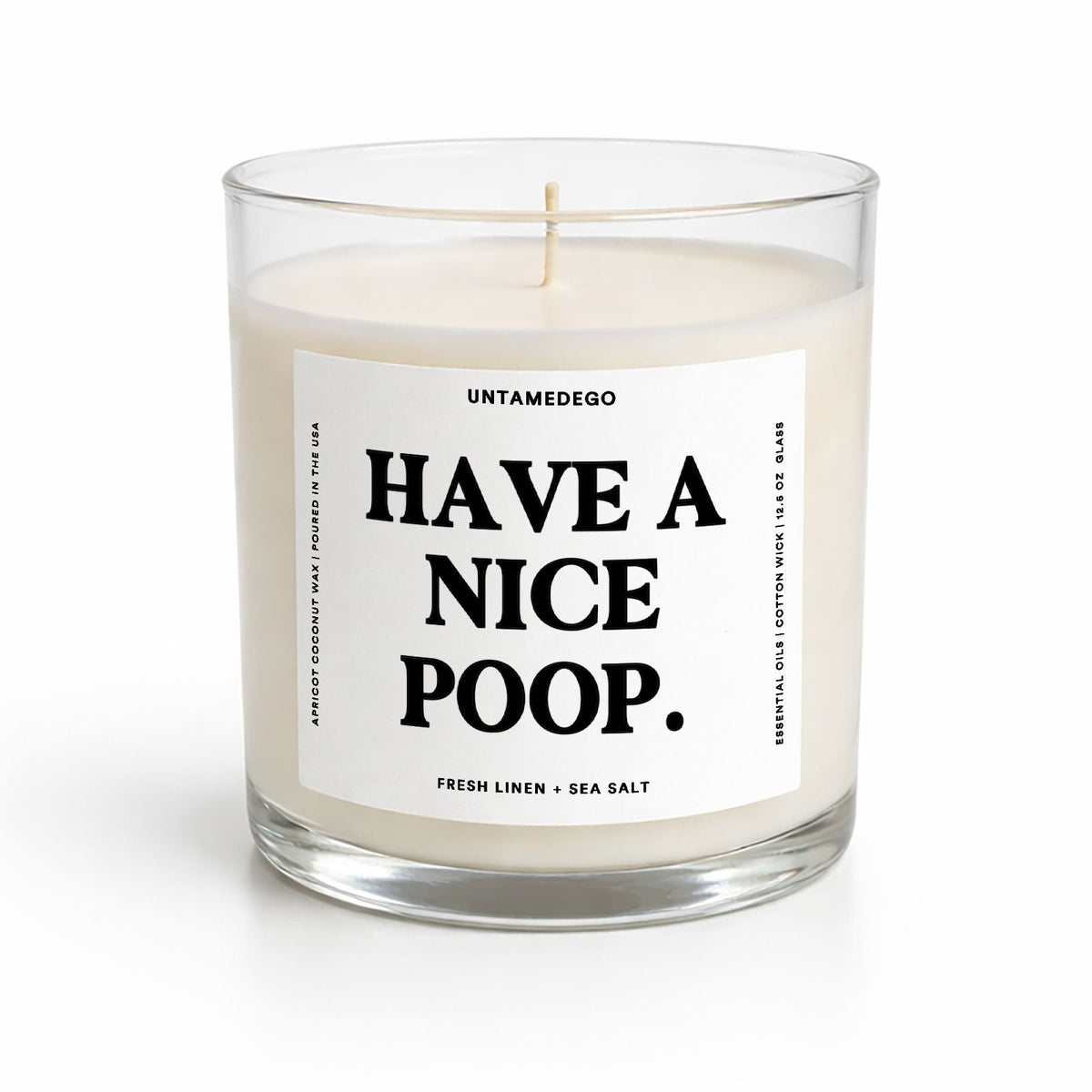 A clear glass jar candle with white wax and a single wick, featuring a white label with bold black text that reads 'HAVE A NICE POOP.' The brand name 'UNTAMEDEGO' is visible at the top of the label.