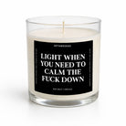 A clear glass jar candle with white wax and a black front label featuring bold white text that reads, 'LIGHT WHEN YOU NEED TO CALM THE FUCK DOWN' with the brand name 'UNTAMEDEGO' above. The candle is photographed on a clean white background.