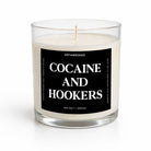 A clear glass jar candle with white wax and a black label reading 'COCAINE AND HOOKERS' in white text, photographed on a clean white background.
