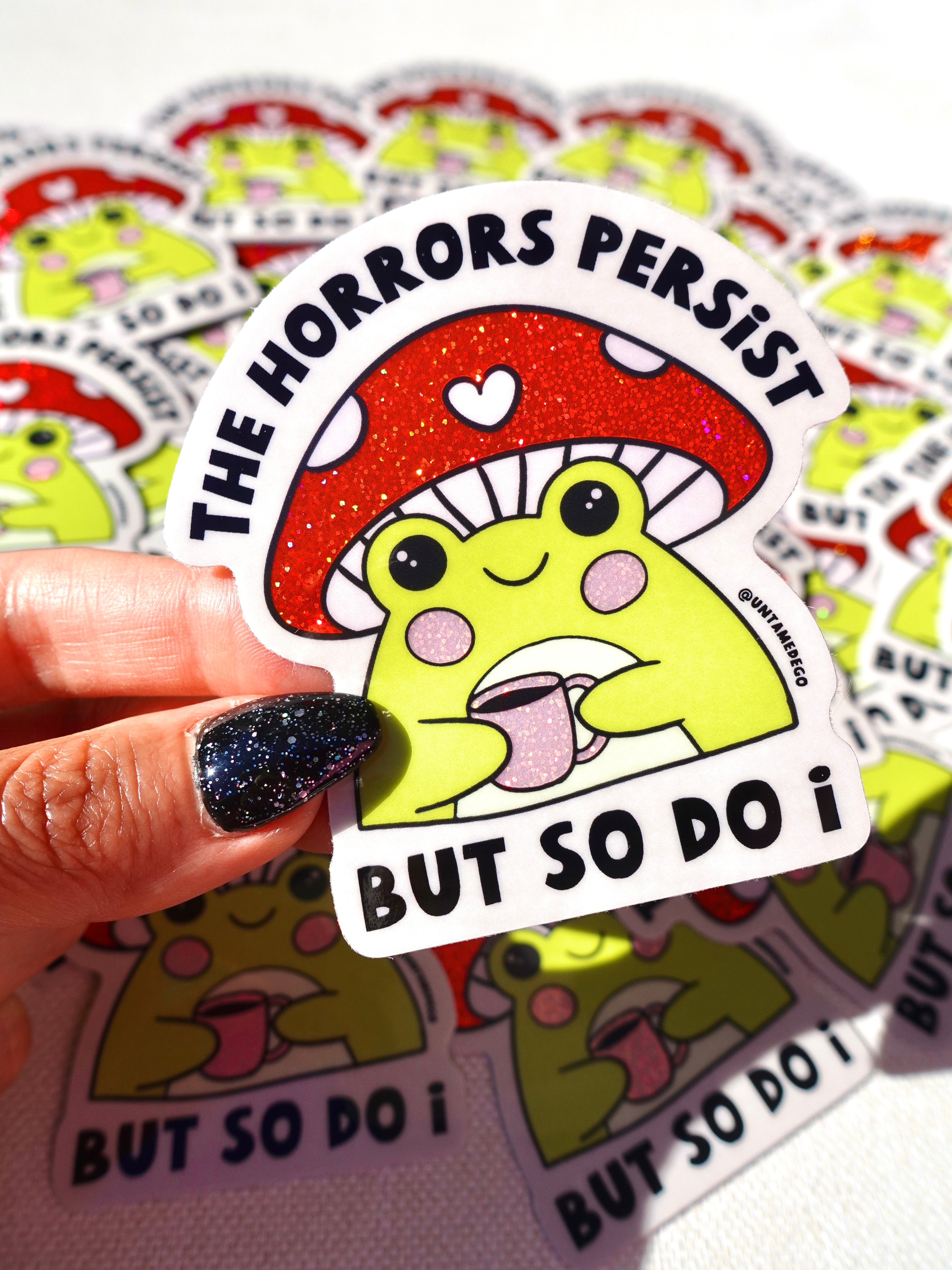 Sticker with a mushroom and text held by a hand, surrounded by more stickers.