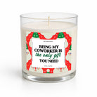 A single-wick candle in a clear glass jar with cream-colored wax and a festive holiday-themed label that reads 'BEING MY COWORKER IS the only gift YOU NEED' in black and green text.