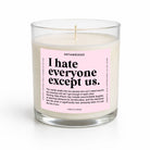 A clear glass jar candle with white wax and a pink label reading 'I hate everyone except us.' by UNTAMEDEGO, shown on a clean white background.
