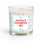 A glass jar candle with white wax and a festive label that reads 'SANTA'S FAVORITE HO' in red text on a light blue background with Santa illustrations, shown on a clean white background.