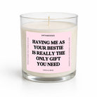 A single-wick candle in a clear glass jar with cream-colored wax and a light pink label featuring bold black text that reads, 'HAVING ME AS YOUR BESTIE IS REALLY THE ONLY GIFT YOU NEED.' The label also shows the brand name 'UNTAMEDEGO' and scent 'VANILLA BEAN.
