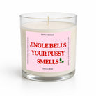 A single-wick soy candle in a clear glass jar with a pink label that reads 'JINGLE BELLS YOUR PUSSY SMELLS' in red text, on a white background.