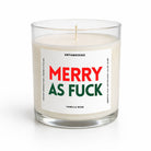 A clear glass jar candle with white wax and a white label reading 'MERRY AS FUCK' in red and green, with 'UNTAMEDEGO' and 'VANILLA BEAN' in smaller black text, on a white background.