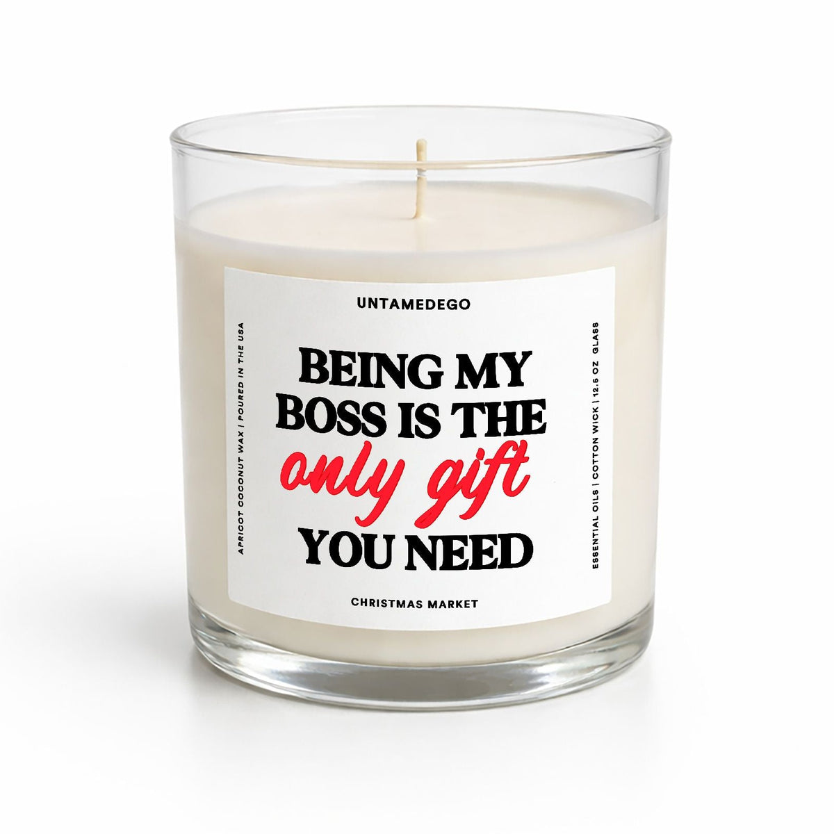 A white wax candle in a clear glass jar with a white label that reads 'BEING MY BOSS IS THE only gift YOU NEED' in black and red text. The brand name 'UNTAMEDGO' is visible at the top of the label.