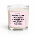 A single-wick candle in a clear glass jar with cream-colored wax and a light pink label featuring bold black text that reads, 'HAVING ME AS YOUR BESTIE IS REALLY THE ONLY GIFT YOU NEED.' The brand name 'UNTAMEDEGO' is visible at the top of the label, with 'CHRISTMAS MARKET' at the bottom.