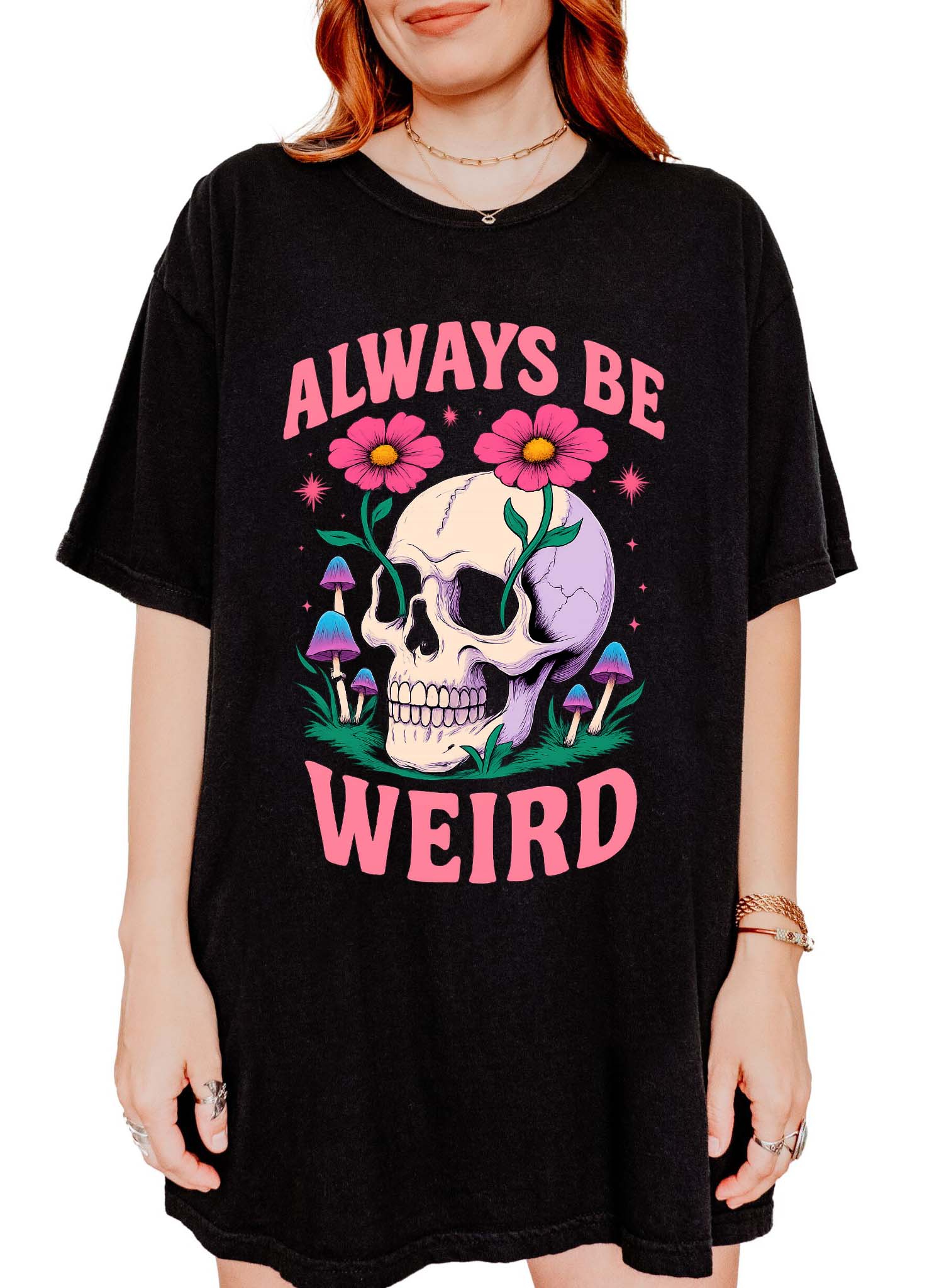 Graphic t-shirt with skull, flowers, and mushrooms design and text saying always be weird