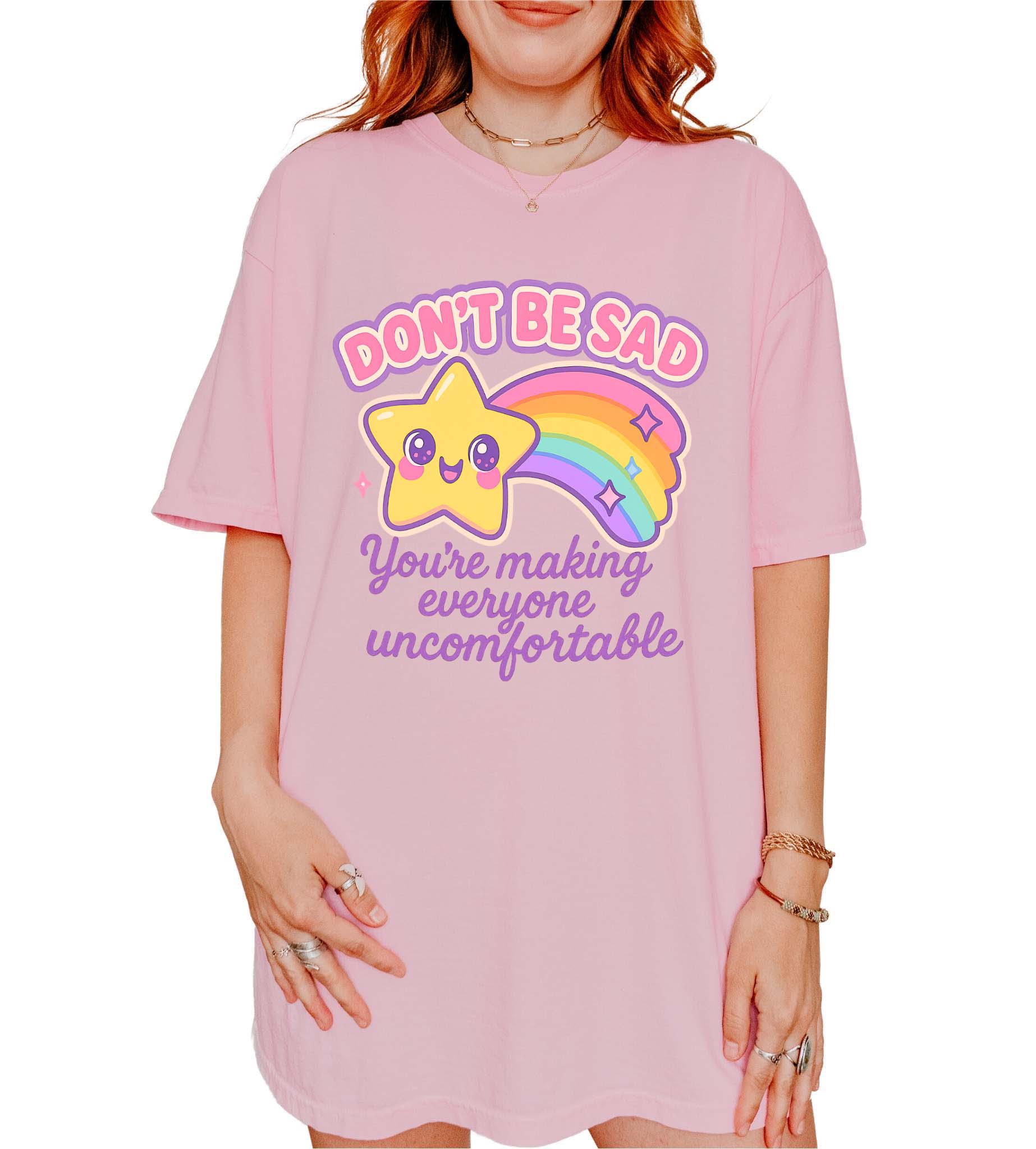Funny graphic t-shirt with cute star and rainbow design and text saying don’t be sad you’re making everyone uncomfortable