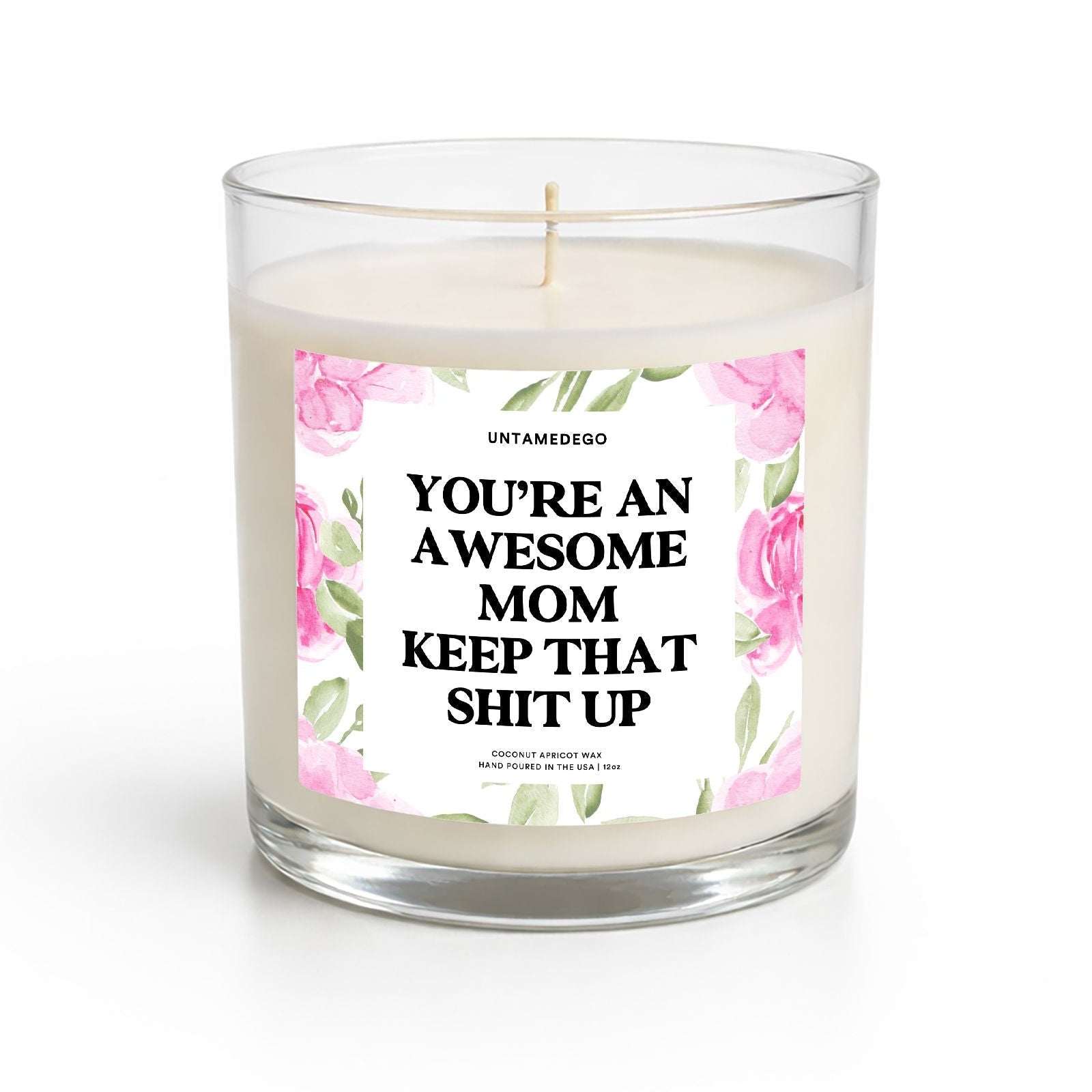 Candle with a label reading 'You're an awesome mom keep that shit up' on a white background