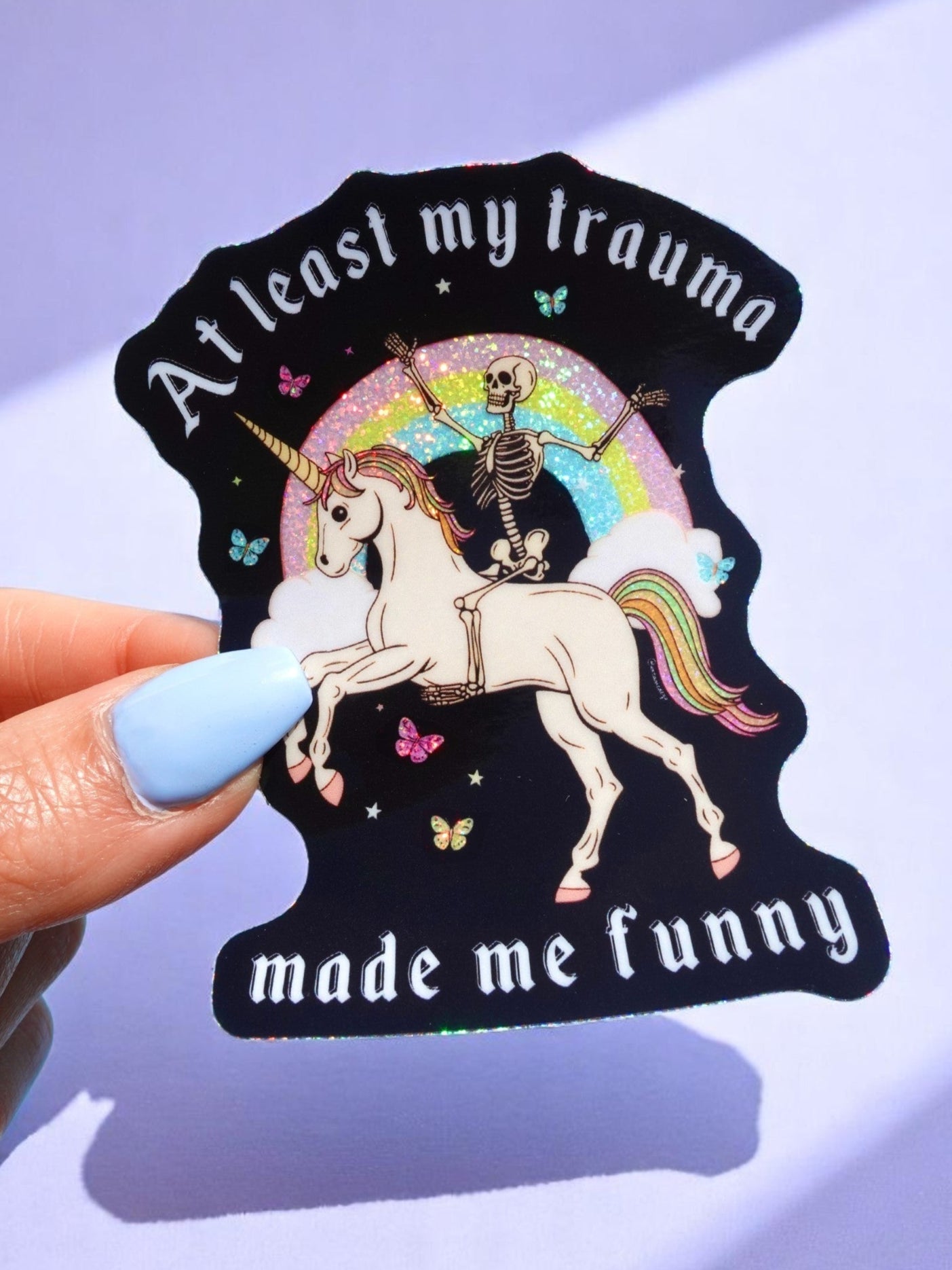 t-least-my-trauma-made-me-funny-unicorn-skeleton-holographic-sticker.