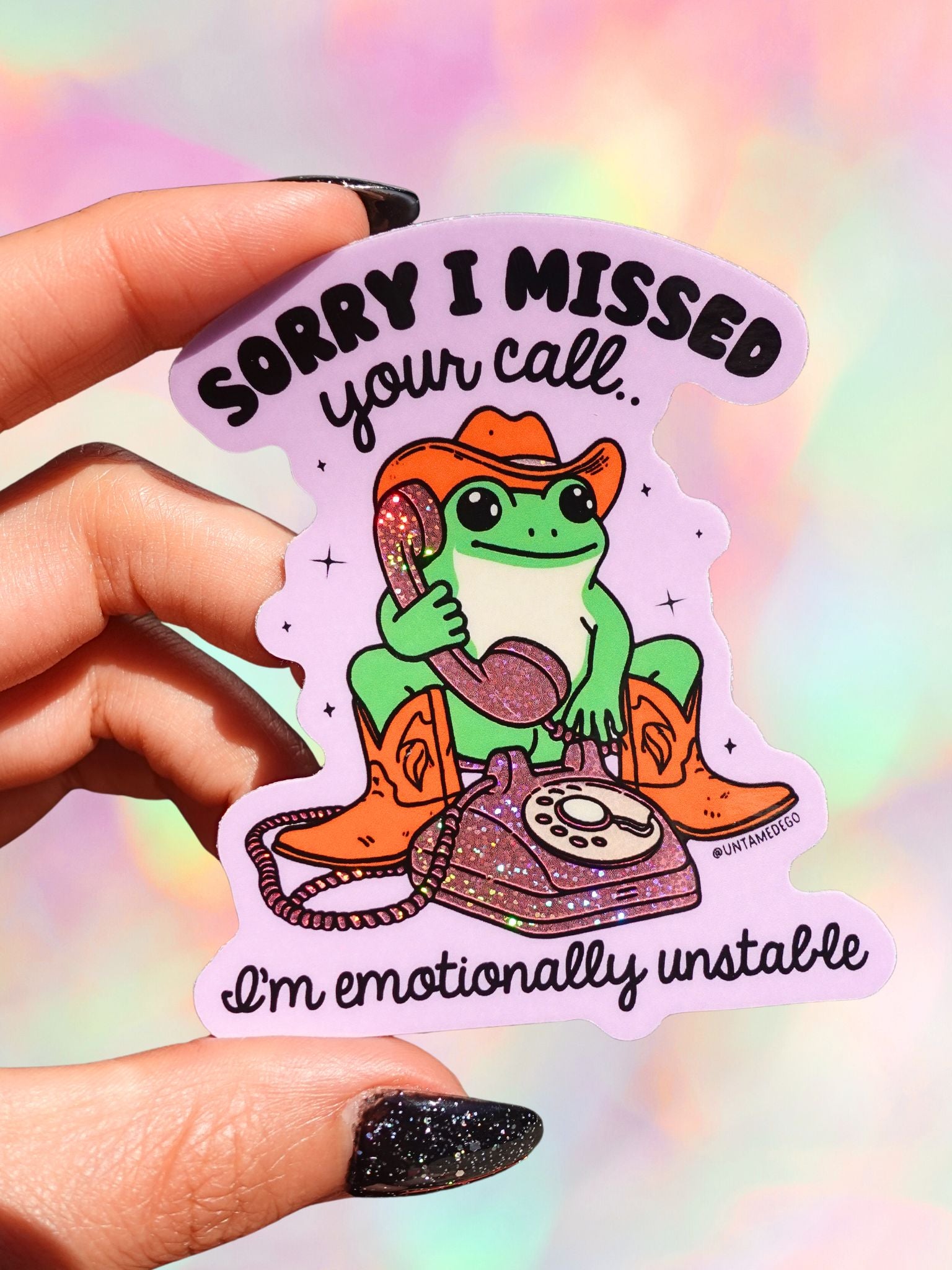 Sticker with a frog in a cowboy hat and boots holding a phone, text 'Sorry I missed your call. I'm emotionally unstable' on a colorful background.