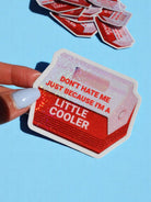 Little Cooler holographic sticker applied to a water bottle. Retro red design with white text. Waterproof vinyl shown in everyday use context.