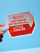 Red holographic cooler-shaped vinyl sticker held in hand against neutral background. Text reads Don't Hate Me Just Because I'm a Little Cooler.