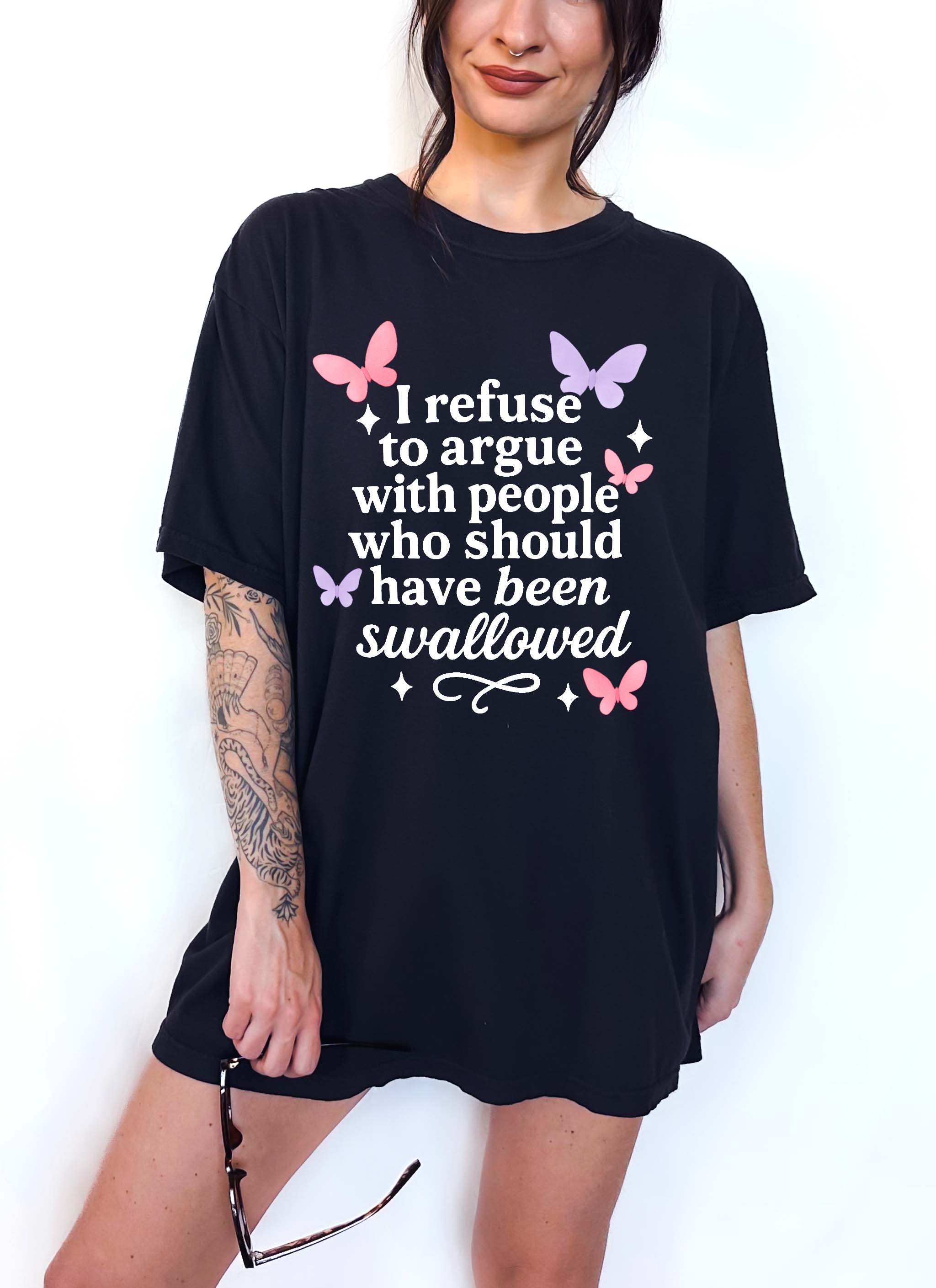 Person wearing a black t-shirt with text and butterfly graphics on a white background