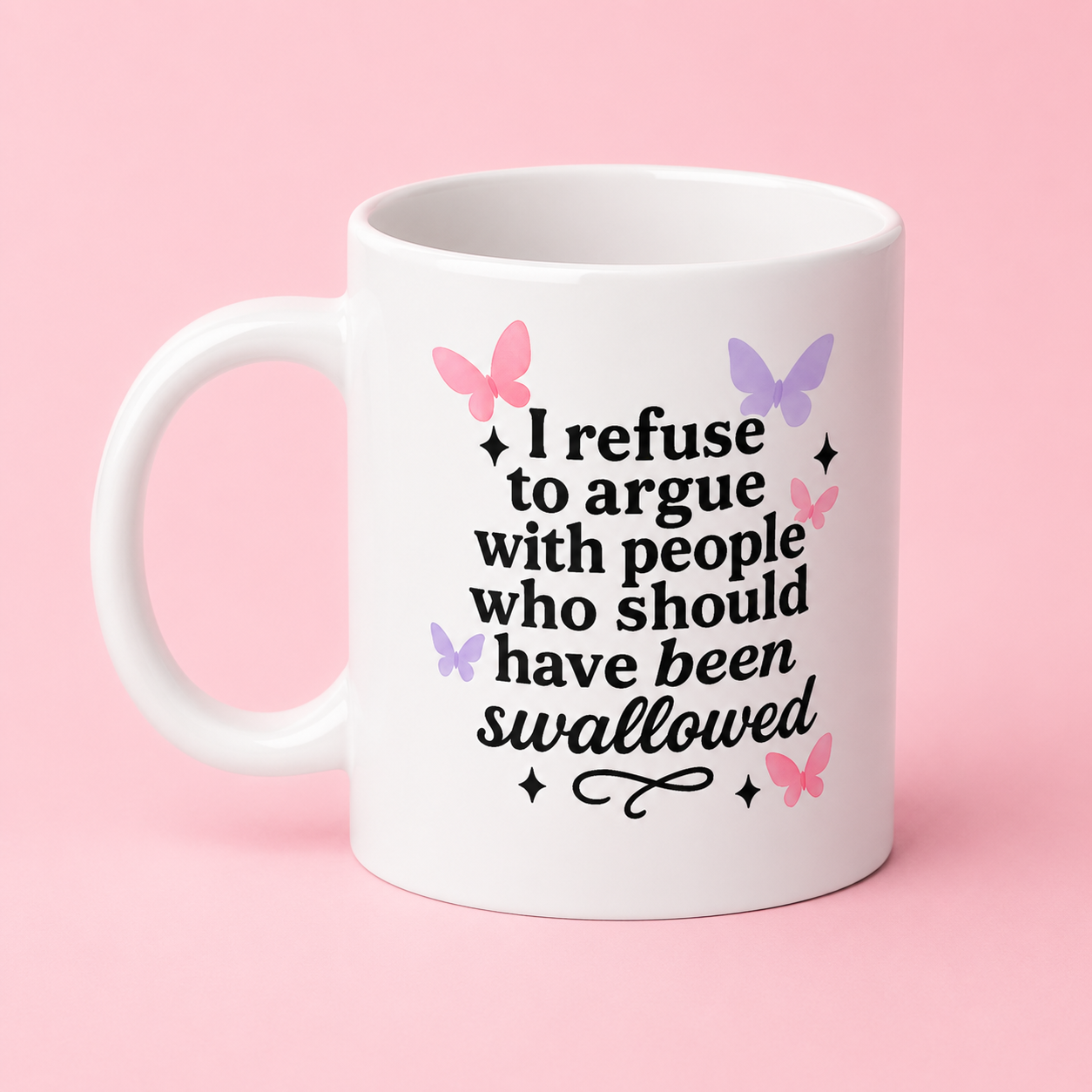 A white ceramic mug with a humorous quote printed in black text and decorated with pink and purple butterflies, set against a solid pink background.