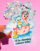 Die-cut holographic vinyl sticker featuring a retro-kawaii baby bear in a bathtub holding a rainbow, with a rubber duck, on a pastel blue background. Bold black text reads: I'll be choosing violence today.