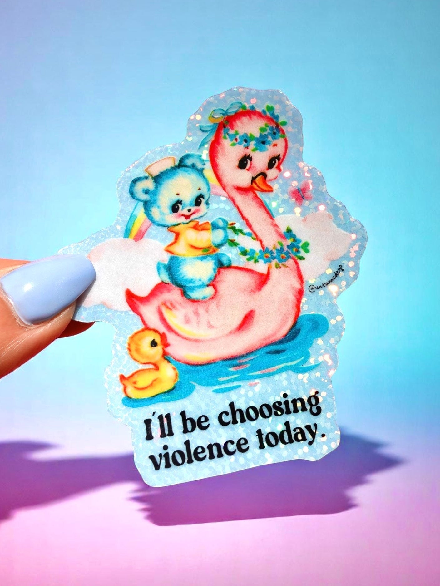 
Die-cut holographic vinyl sticker featuring a retro-kawaii baby bear in a bathtub holding a rainbow, with a rubber duck, on a pastel blue background. Bold black text reads: I'll be choosing violence today.