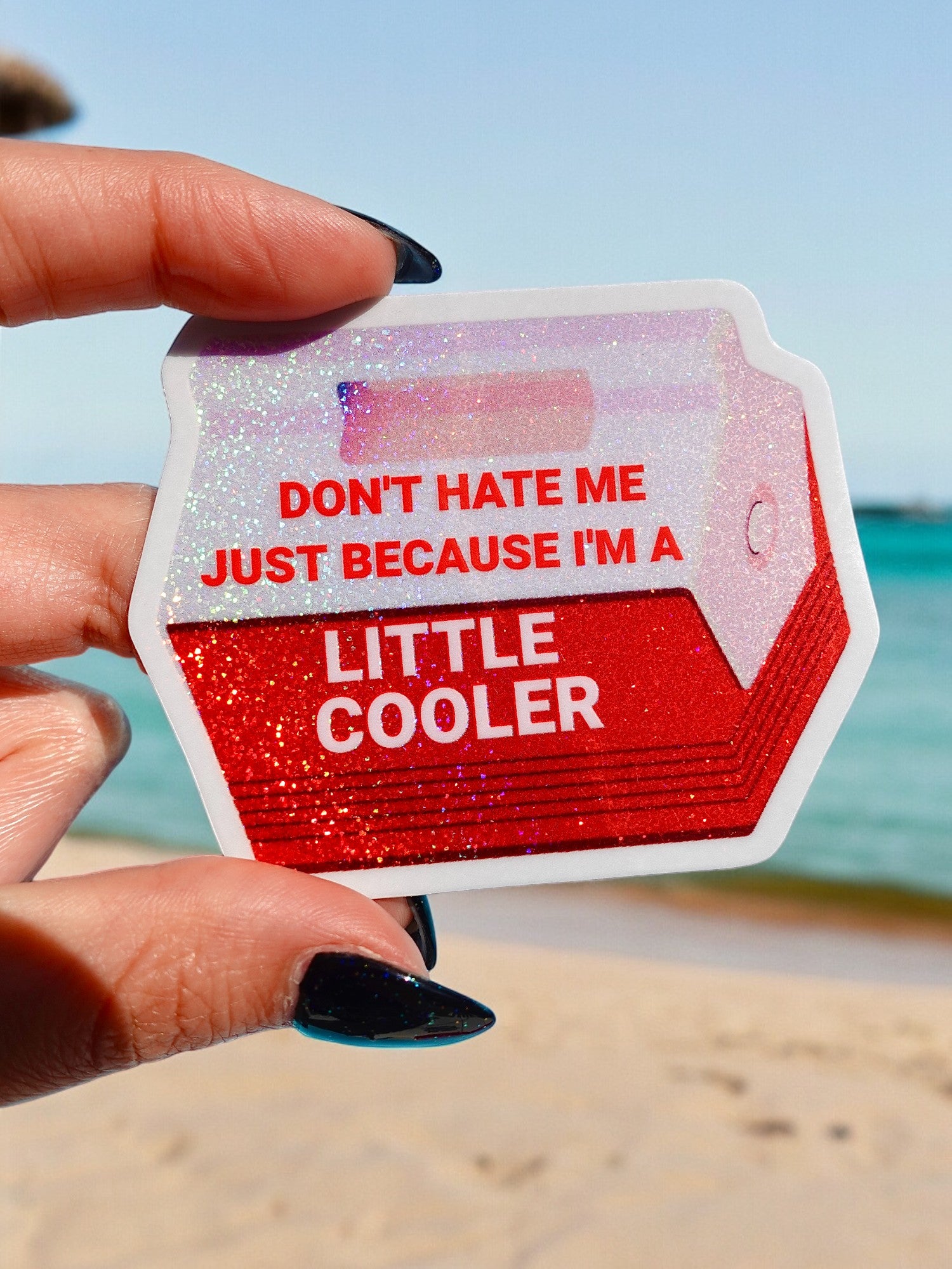 Funny red vinyl sticker shaped like a retro drink cooler with holographic glitter. Text reads “Don’t Hate Me Just Because I’m a Little Cooler.”