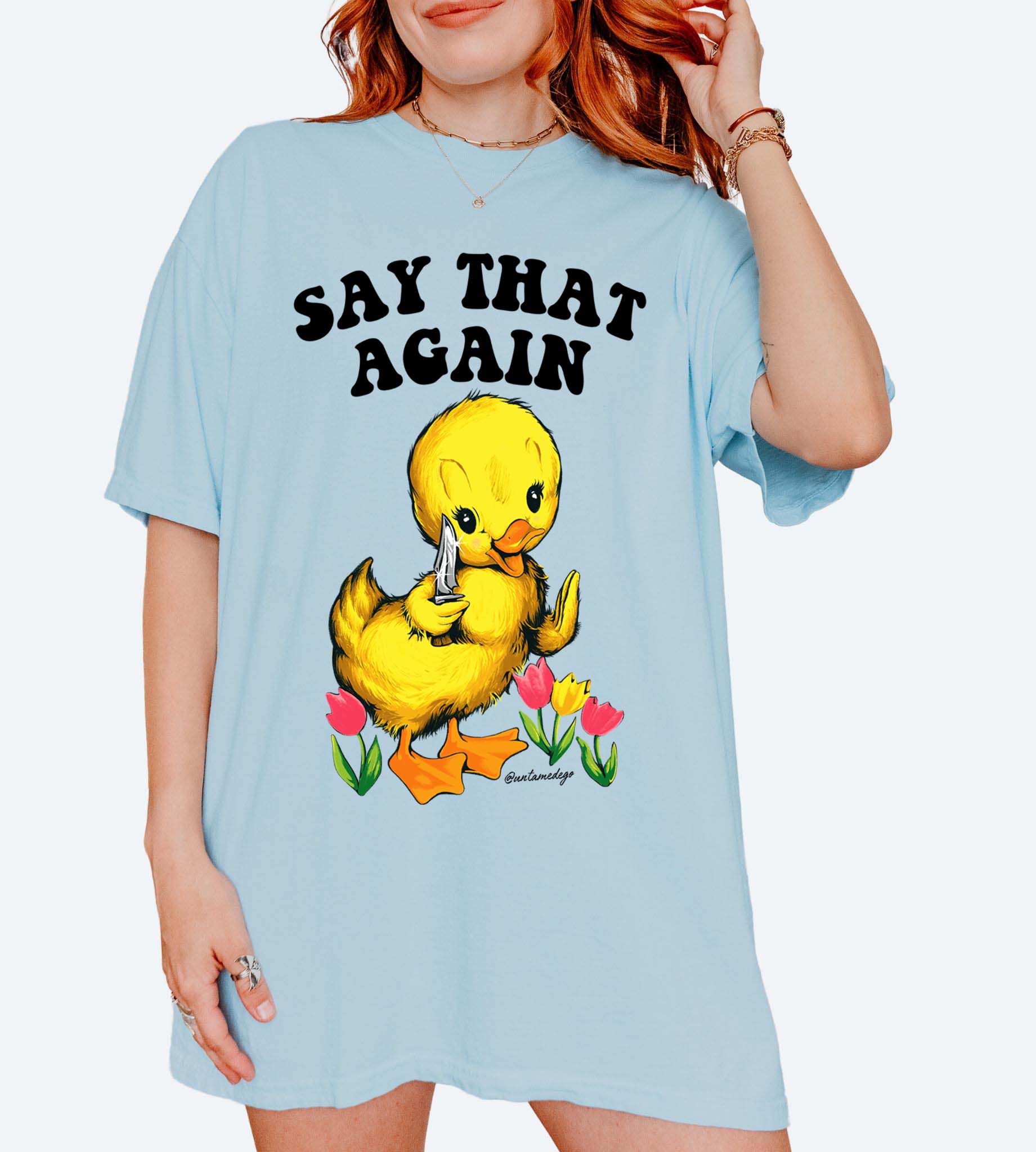 Funny graphic t-shirt with cute duck holding knife and text saying say that again