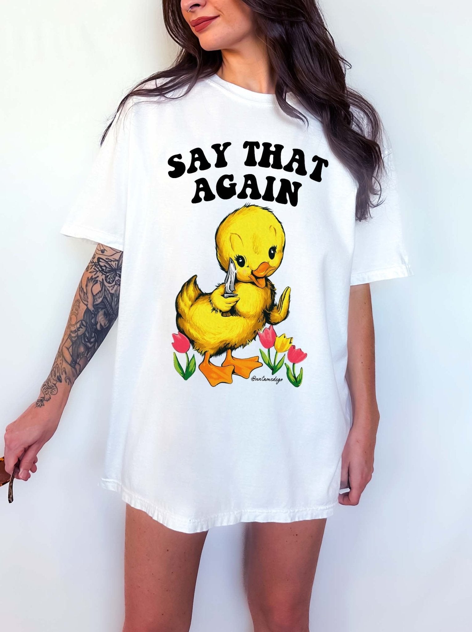 Funny graphic t-shirt with cute duck holding knife and text saying say that again