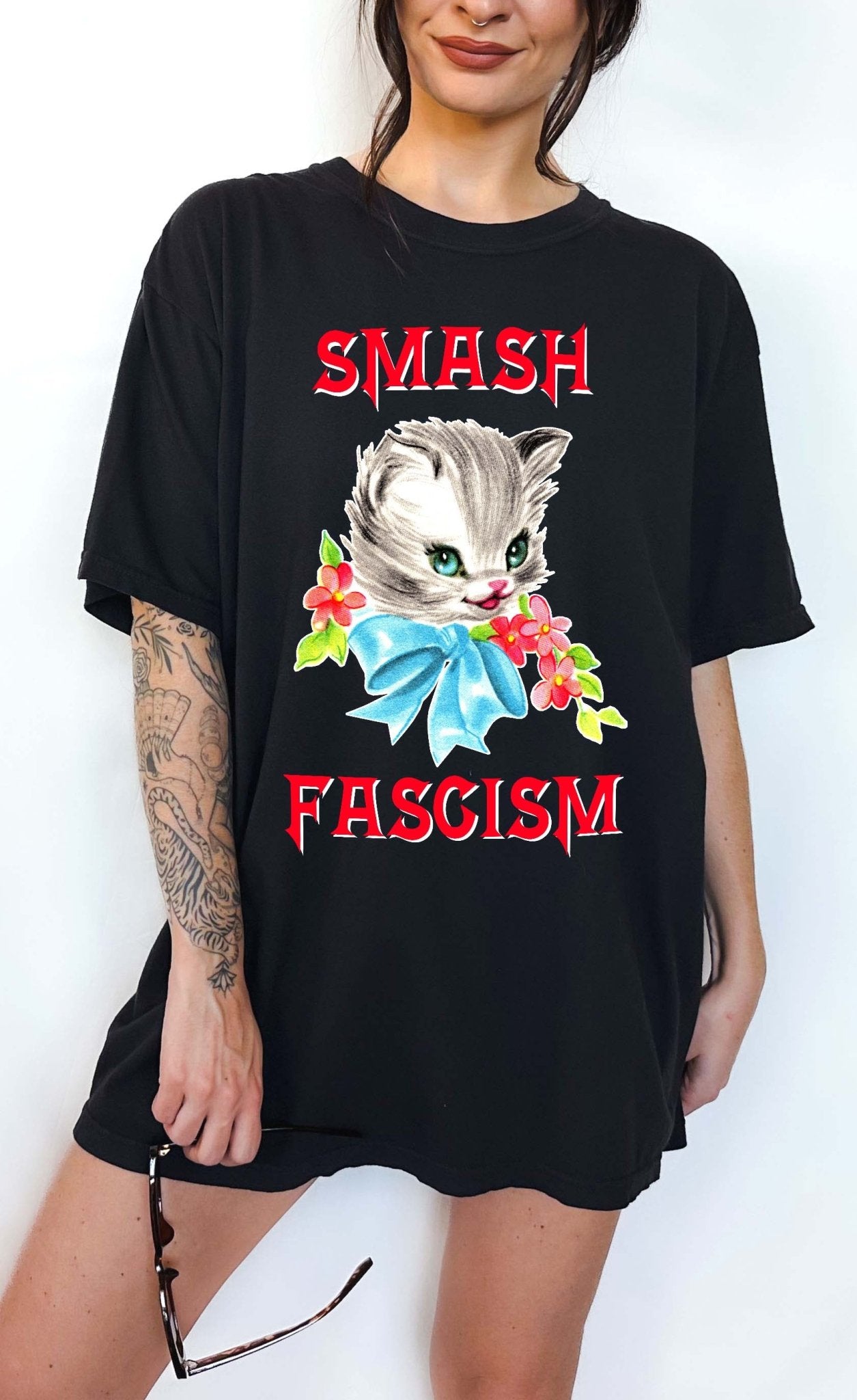 Graphic t-shirt with cute cat illustration and bold protest text reading smash fascism