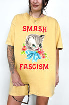 Graphic t-shirt with cute cat illustration and bold protest text reading smash fascism