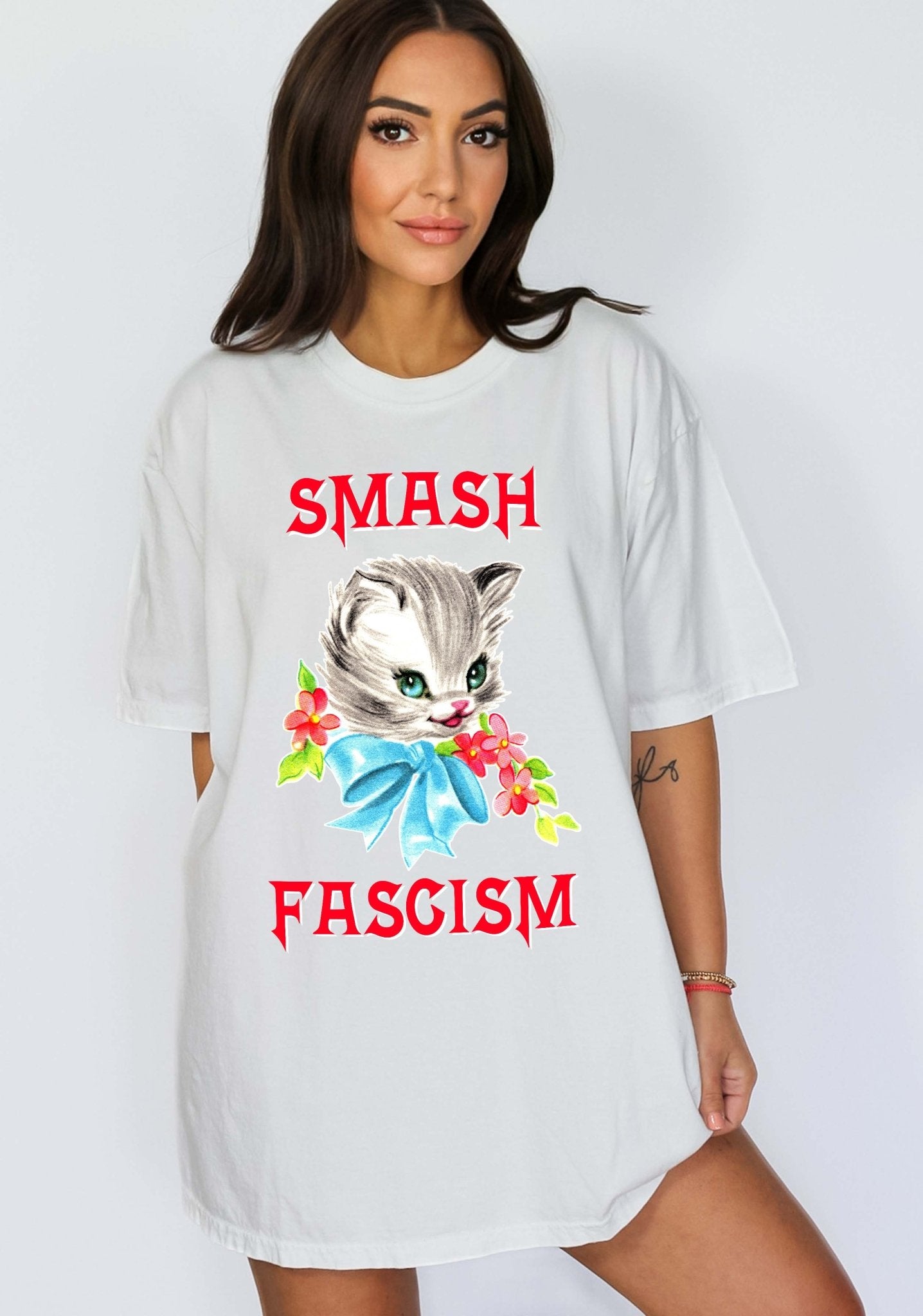 Graphic t-shirt with cute cat illustration and bold protest text reading smash fascism
