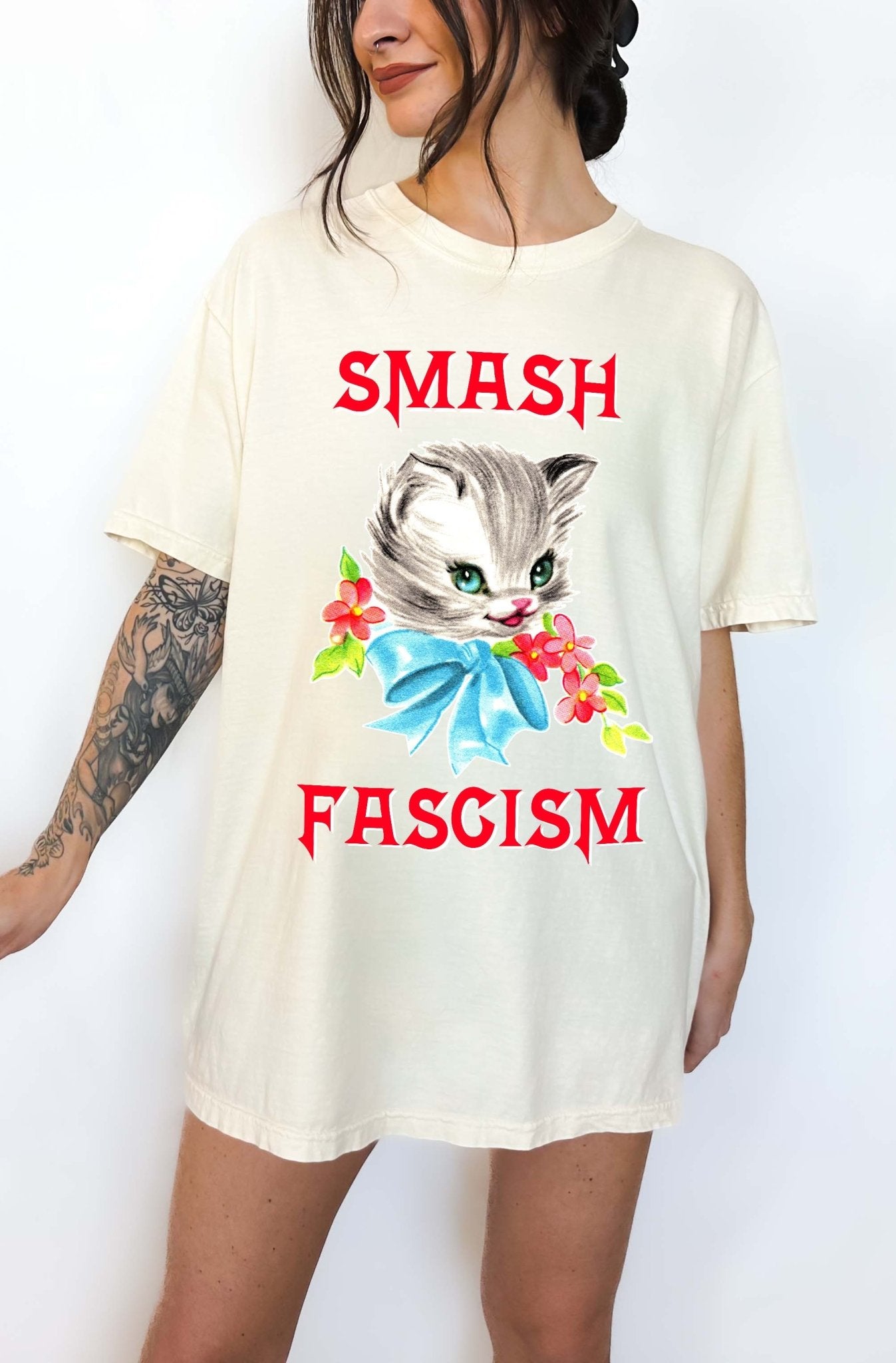 Graphic t-shirt with cute cat illustration and bold protest text reading smash fascism