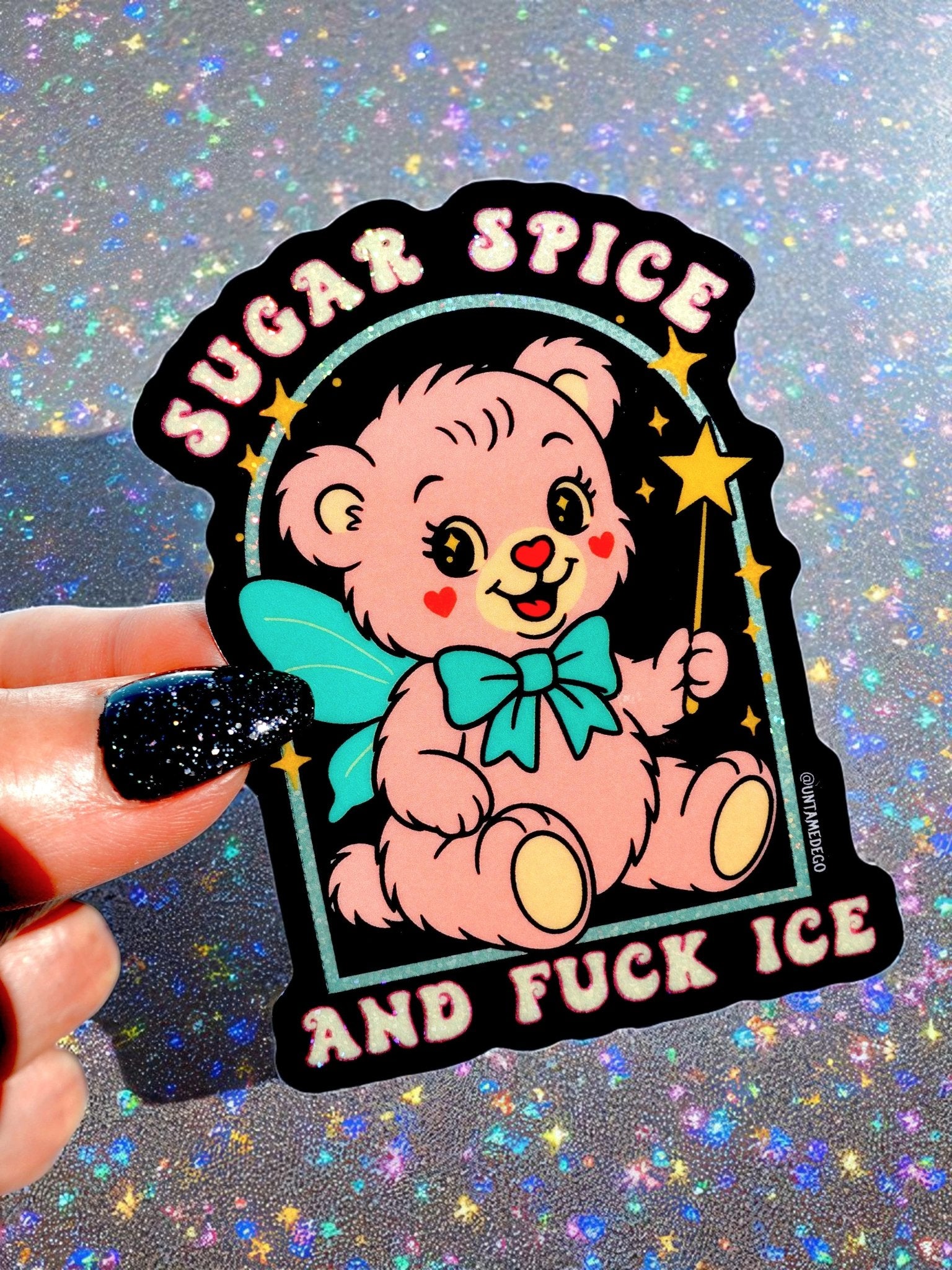 Die-cut holographic glitter vinyl sticker on a black background featuring a retro kawaii bear with a teal bow and stars. Arched text at top reads Sugar Spice and text at bottom reads And Fuck ICE.