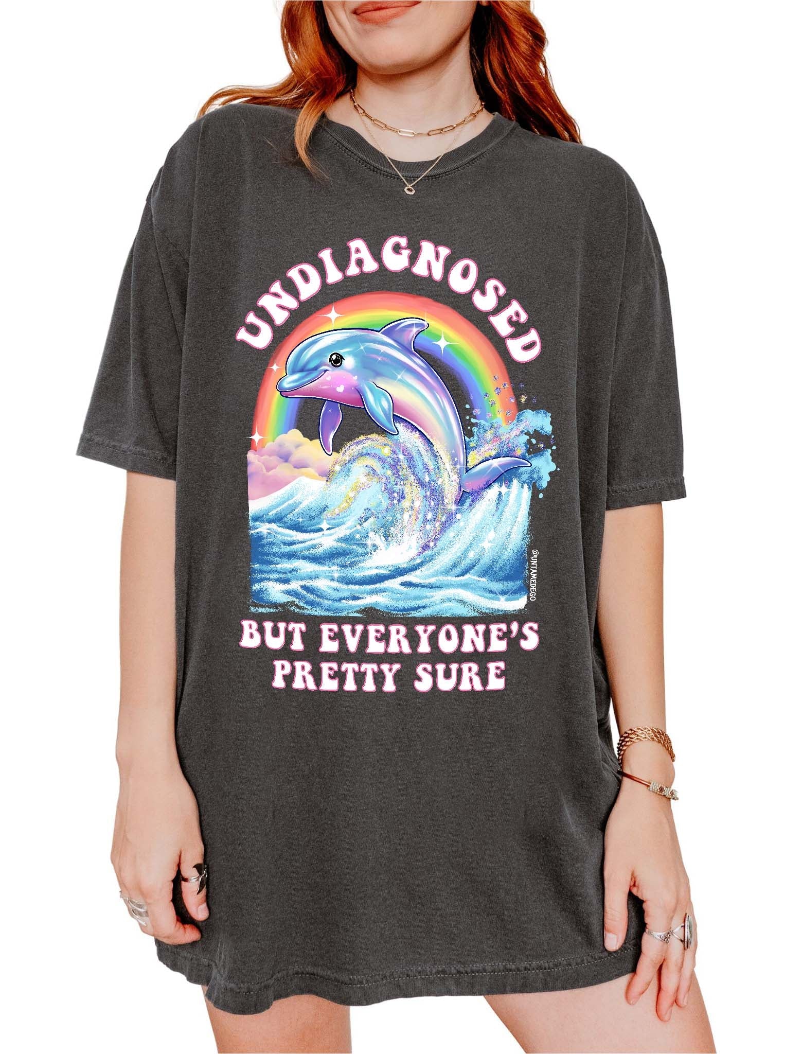 Funny graphic t-shirt with dolphin and rainbow design and text saying undiagnosed but everyone’s pretty sure