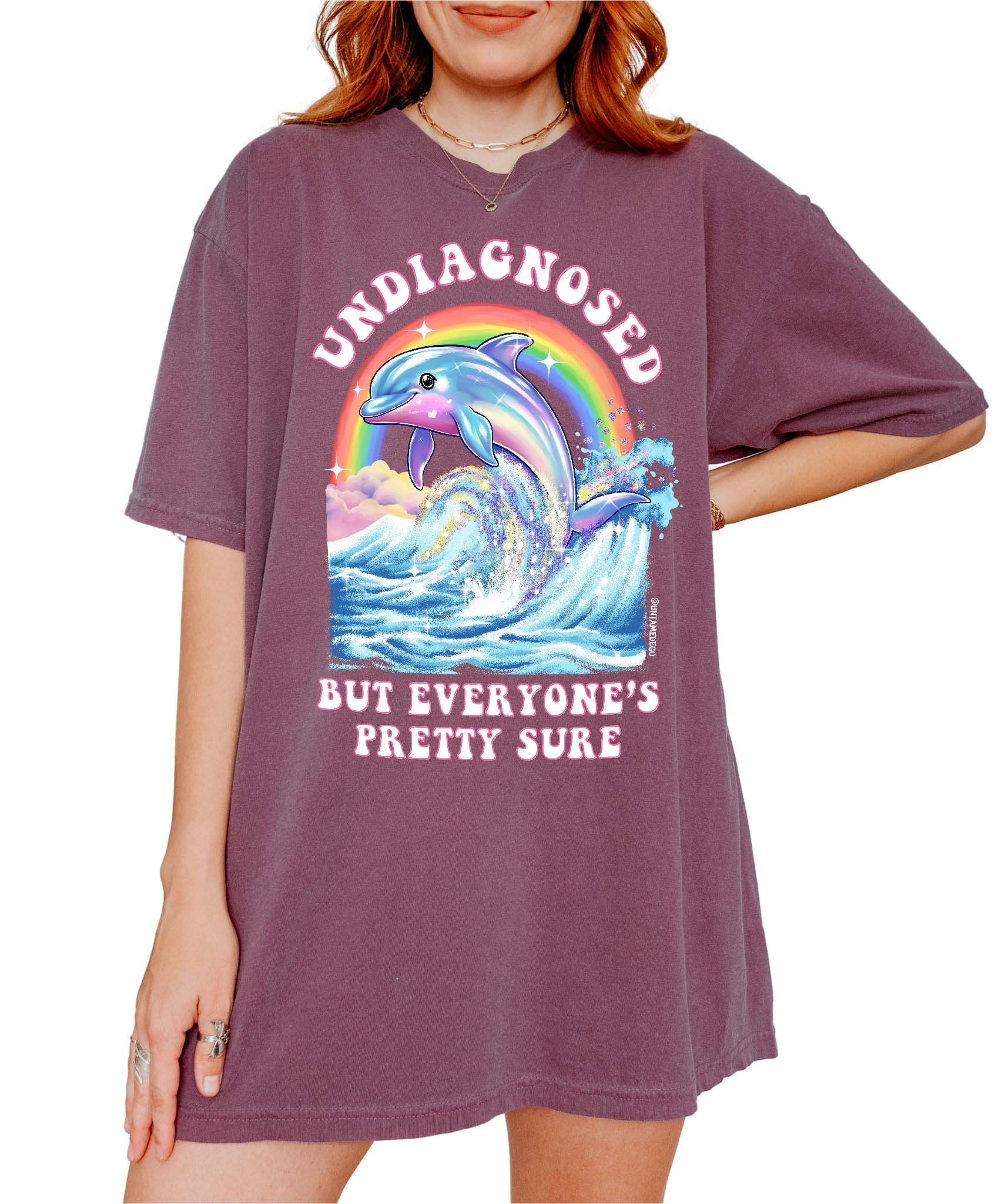 Funny graphic t-shirt with dolphin and rainbow design and text saying undiagnosed but everyone’s pretty sure