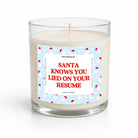 A glass jar candle with white wax and a humorous Christmas-themed label that reads 'SANTA KNOWS YOU LIED ON YOUR RESUME' in red text on a light blue background with Santa illustrations.
