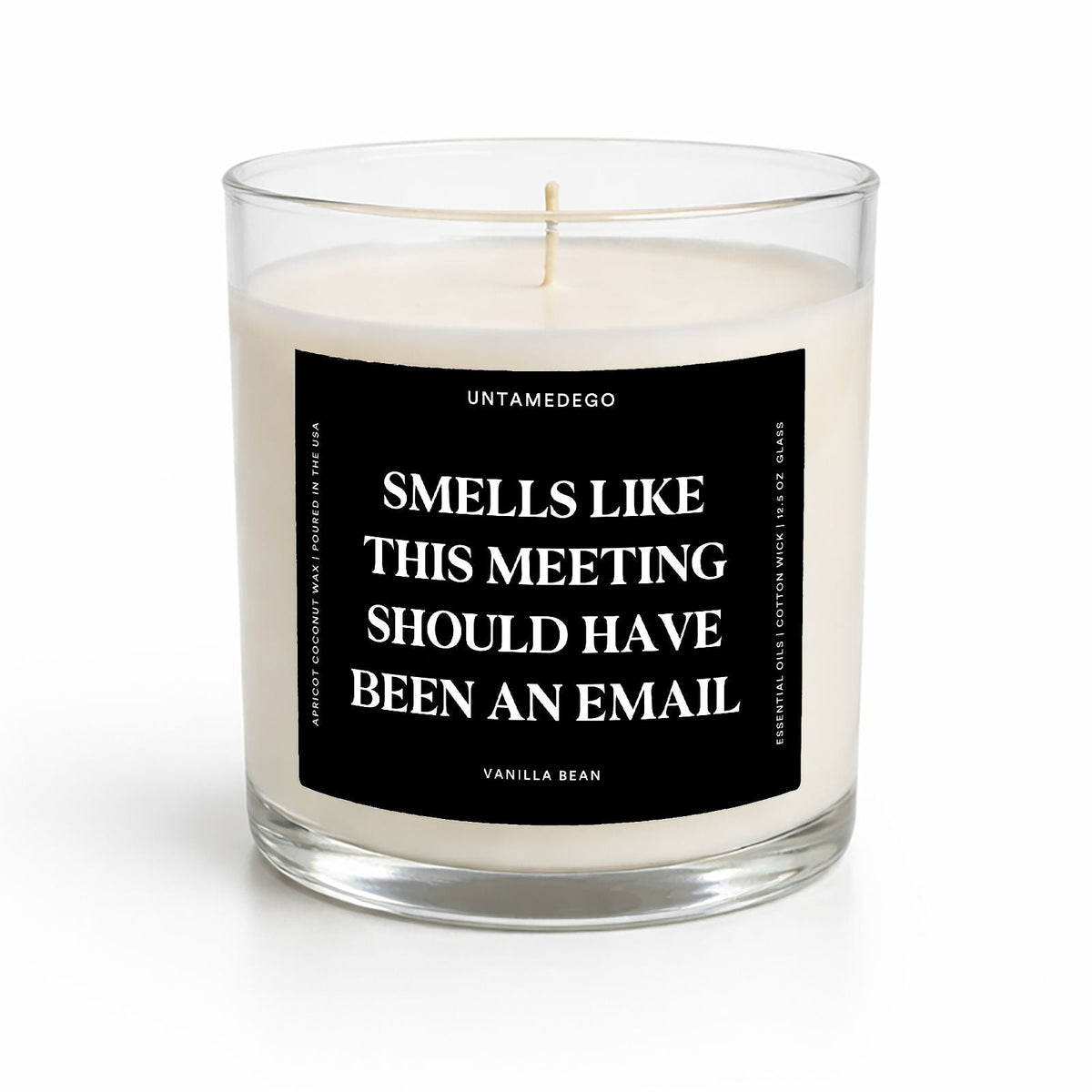 A clear glass jar candle with white wax and a black label featuring white text that reads 'SMELLS LIKE IT'S TIME FOR A SPREADSHEET' by Untamedo. The candle is photographed on a clean white background with a soft shadow.