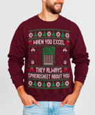 A man wearing a maroon crewneck sweatshirt with a festive Christmas-themed spreadsheet joke graphic. The graphic features green and white holiday patterns, a spreadsheet icon, and the text 'WHEN YOU EXCEL THEY ALWAYS SPREADSHEET ABOUT YOU'.