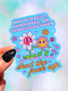 Die-cut holographic vinyl sticker on a light blue background featuring two retro smiley-face flowers with colorful floral accents. Text reads Why Be Racist Homophobic Or Transphobic When You Could Just Shut The Fuck Up.
