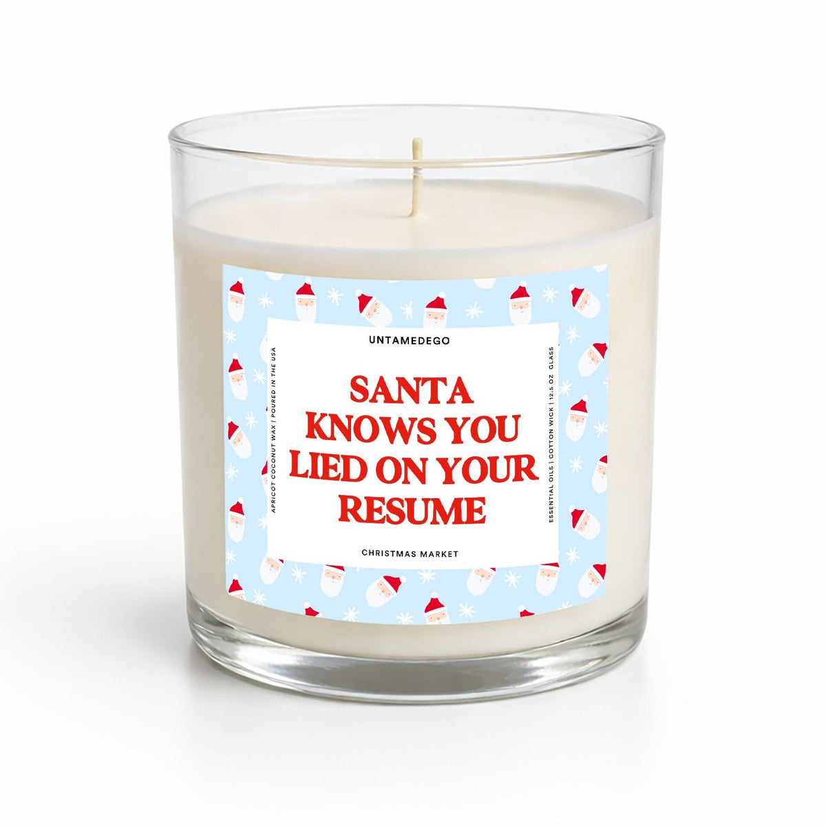 A clear glass jar candle with white wax and a single wick, featuring a festive light blue label with Santa illustrations and bold red text that reads, 'SANTA KNOWS YOU LIED ON YOUR RESUME.'.