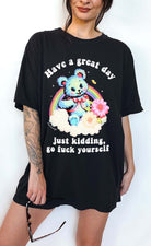 Funny graphic t-shirt with cute bear and rainbow design and sarcastic text saying have a great day just kidding go fuck yourself