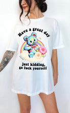 Funny graphic t-shirt with cute bear and rainbow design and sarcastic text saying have a great day just kidding go fuck yourself