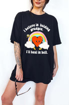 Funny sarcastic black t-shirt with retro heart and rainbow graphic reading I believe in holding grudges I’ll heal in hell