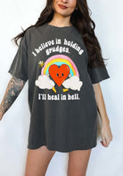 Funny sarcastic black t-shirt with retro heart and rainbow graphic reading I believe in holding grudges I’ll heal in hell
